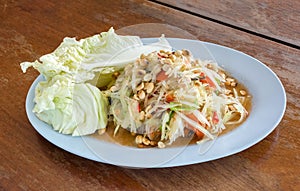 SomTam, Green papaya salad Thai cuisine spicy delicious on wooden plate with copy space