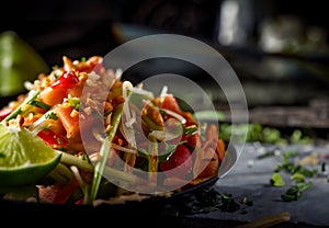 Somtum or papaya salad in Thai on wooden table .green papaya salad in plate on dark wooden background.Thai Food Concept.