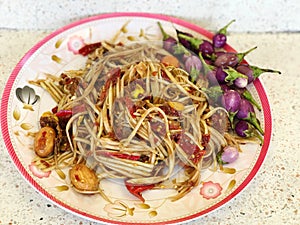 somtum, papaya spicy salad with salted eggplant and chilli in a plate photo