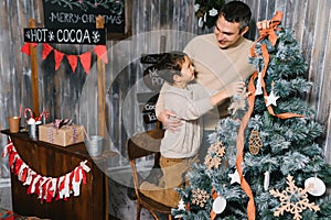 Son and dad decorating the christmas tree at home