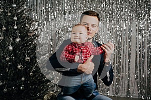 Son and dad. A little boy in the arms of his father at the Christmas tree