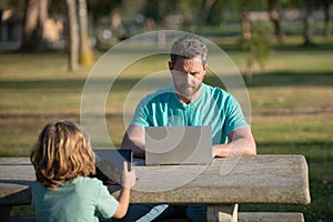 Son with daddy learning lesson. Blogging. Family education Concept. Father teaching his little toddler boy how to use