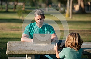 Son with daddy learning lesson. Blogging. Family education Concept. Father teaching his little toddler boy how to use