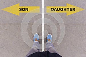 Son or Daughter choice, text on asphalt ground, feet and shoes on floor
