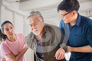Son and daughter help support a senior father have a backache, Back pain in elderly adults, Asian family concepts