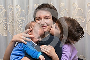 Son and daughter kissing her mother