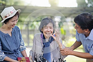 Son and daughter in law give a present to elderly mother