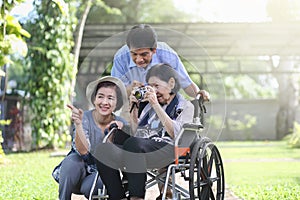 Son and daughter in law looking after elderly mother in backyard