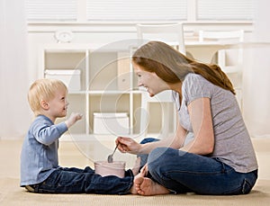 Son eats ice cream from tub with excited mother