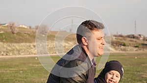 Son falls on grass and laughs during the soccer game with his funny dad slow motion