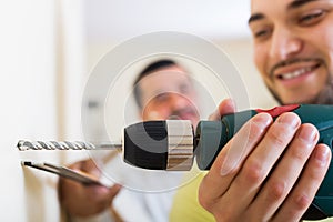 Son and father drilling wall