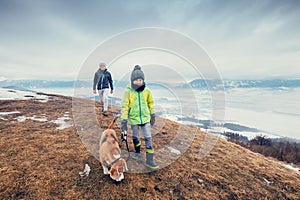 Son and father walk with dog on hill with top view panorame on c