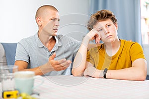 Son feeling sad and father talking to him