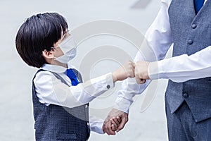 Son fist bump to father with love Little child wear protective face mask when go out with parent at outdoors for protection of air