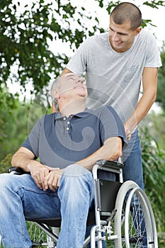 Son going on stroll with father on wheelchair