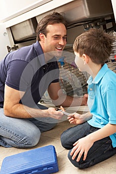 Son Helping Father To Mend Sink