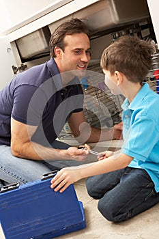 Son Helping Father To Mend Sink