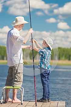 Son helps his father to fish