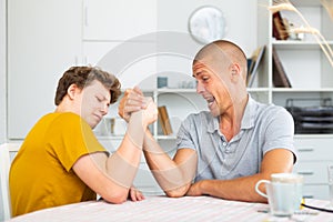 Son and his dad arm wrestling