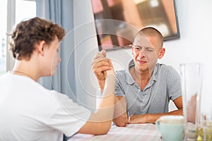 Son and his dad arm wrestling