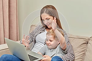 The son and his mother are sitting at home and chatting online. Laptop on my lap