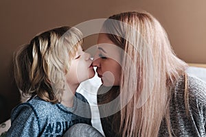 Son is kissing his mother. Mom and son. Happy mother`s day. Mother hugging her child at home