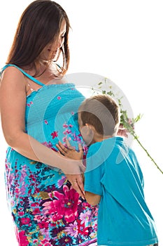 Son kissing pregnant belly of his mother