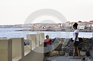 Son and mother walking on street of ?ncient city of Sozopol in Bulgaria