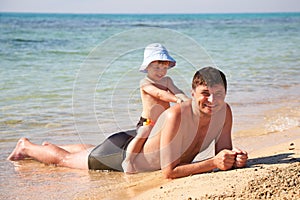 Son sitting astride a father
