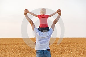 Son sitting on father`s shoulders with my hands up. Happy childhood and fatherhood