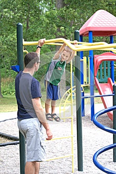 Son smiling at dad during father son bonding at the playground