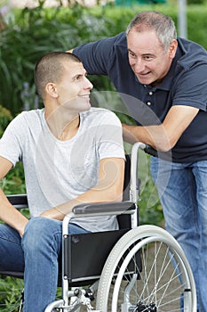 Son in wheelchair and father on walk