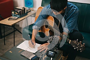 Songwriter or composer composing sheet music writing on paper Professional songwriter with audio recorder digital music production