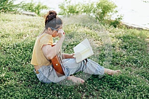Songwriter create and writing notes,lyrics in the book on grass at parks beside the sea and building city background photo