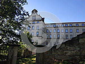 Sonnenstein castle behind wall and trees in Pirna