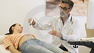 Sonographer doing abdomen ultrasound examination of woman in hospital
