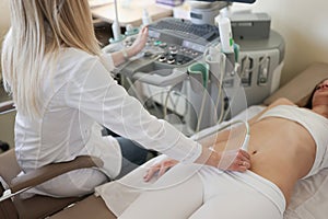 Sonographer hand examining woman with ultrasound scanner