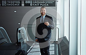 Soon hell be soaring towards success. an executive businessman walking through an airport during a business trip.