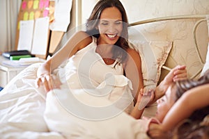 And soon there will be four. Shot of a happy little girl lying in bed with her dad and pregnant mother.