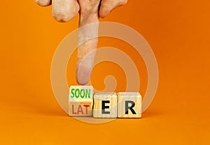 Sooner or later symbol. Businessman turns wooden cubes and changes the word Later to Sooner. Beautiful orange table orange