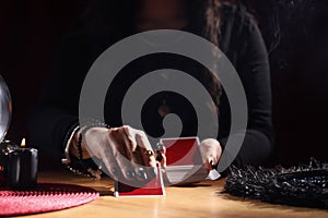 Soothsayer predicting future with cards at table indoors, closeup