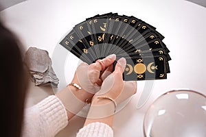 Soothsayer with tarot card at table, closeup