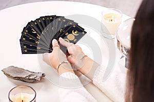 Soothsayer with tarot card at table, closeup