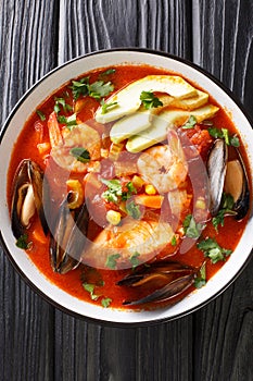 Sopa de Mariscos Seafood Soup closeup in the plate. Vertical top view photo