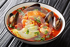 Sopa de Mariscos seafood soup with cod, shrimp, mussels, vegetables and avocado close-up in a bowl. Horizontal photo