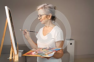 Sophisticated elderly lady holds a brush in her hands