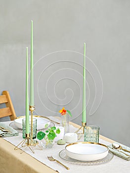 Sophisticated green candles and the combination of white and gold create a luxury setting for a special occasion&