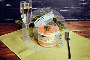 Sophisticated salad with champagne and fork on a wooden background