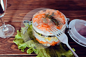 Sophisticated salad with champagne, lettuce and fork on a wooden background