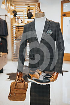 Sophisticated suit with derby shoes and a bag on the mannequin on the display